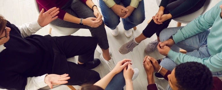 Overhead shot of group therapy discussing freelapse vs. relapse