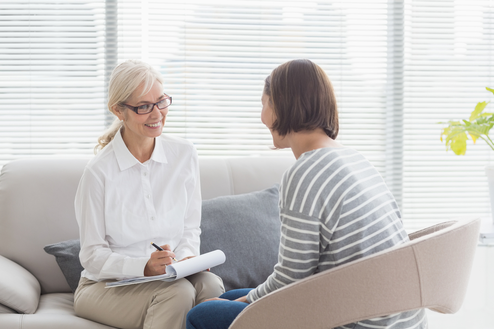 smiling therapist with woman patient for addiction and mental health treatment