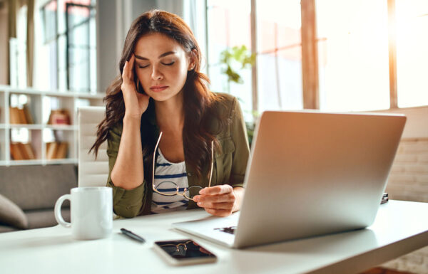 Woman at desk stressed and overwhelmed by alcohol problems