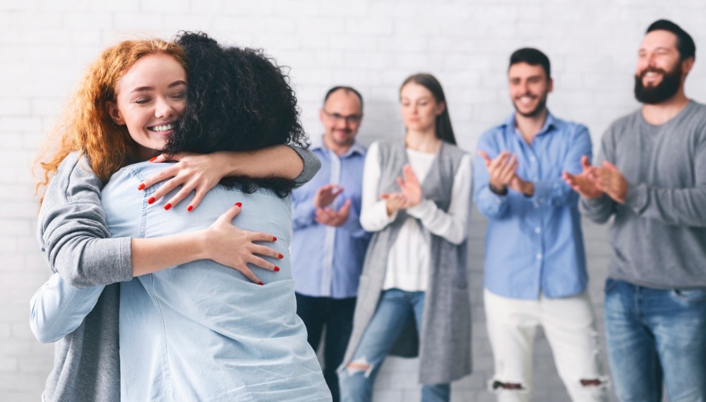 friend hugging in support group for mental health treatment program