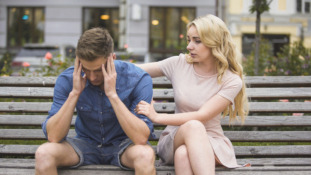 couple sitting on a bench, showing compassion