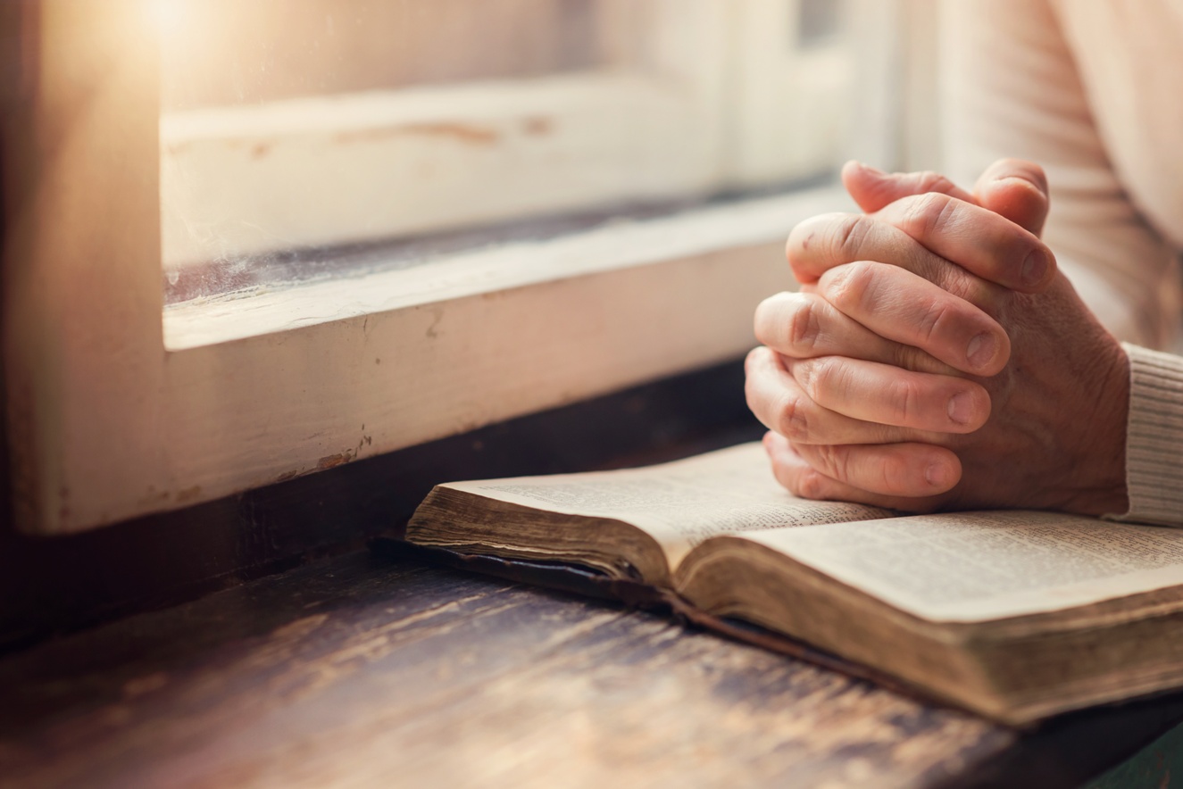hand of a woman with bible, praying