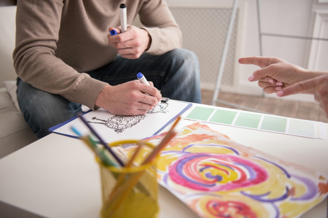 Appealing male hands sketching during creative therapy session
