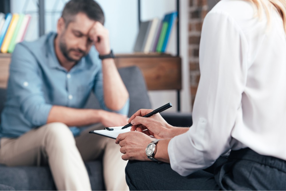 Middle aged man with a therapist is treatment session for his alcohol abuse problem